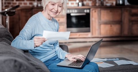 senior woman checking bills using laptop