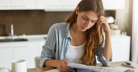 stressed woman reviewing bills at home