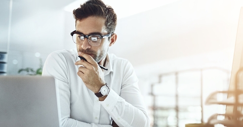 Man using laptop seeking a solution to a problem.