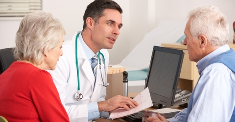 male doctor talking to senior couple