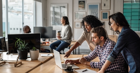 three colleagues using laptop together