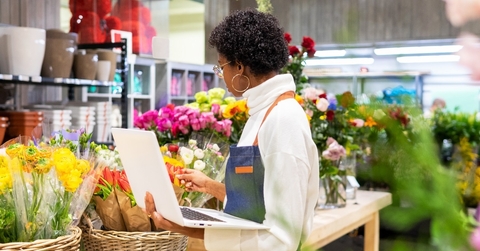 african american female florist inspecting flowers