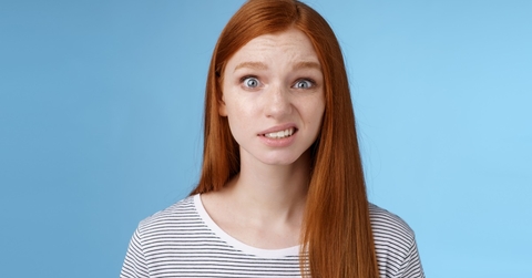 young girl frowning over blue background