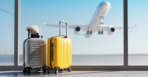 luggage with airplane flying at back