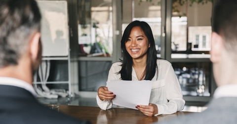 asian woman giving resume to managers