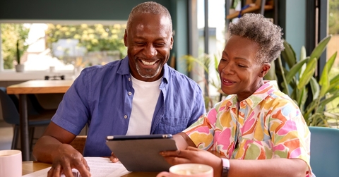 senior couple reviewing bills using tablet