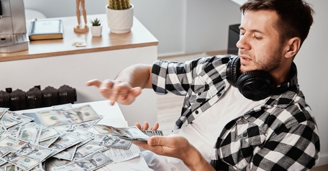 man counts dollar banknotes