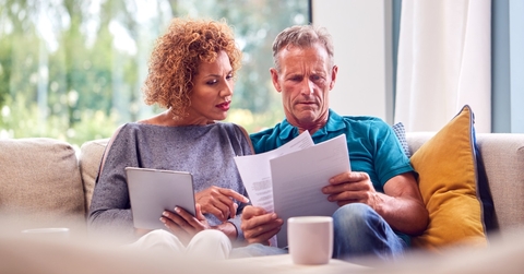 senior couple reviewing bills on couch