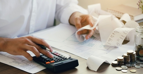 man calculating expenses using calculator