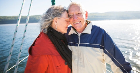smiling senior couple on sailboat