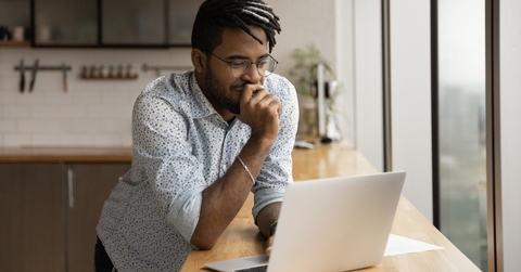 freelancer stands at kitchen desk