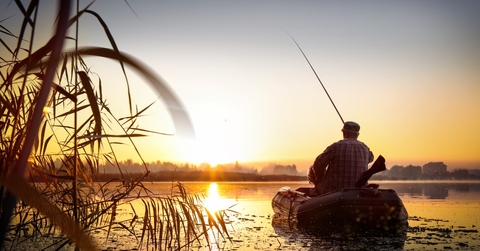 man fishing at sunset in lake