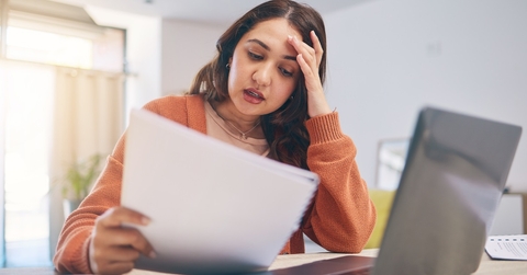 stressed woman reviewing bills at home