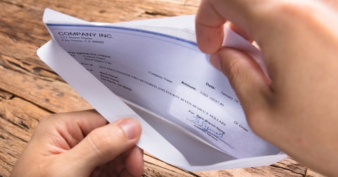 businessman opening envelope with paycheck