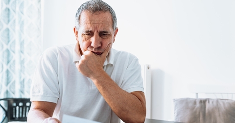 stressed senior man reviewing bills