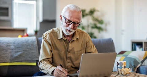 senior man reviewing insurance papers online