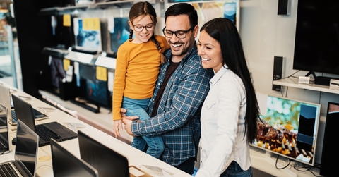 Happy family buying laptop in store