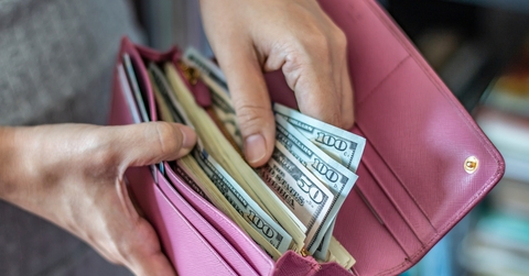 Woman taking out dollar from wallet
