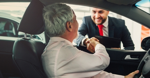 senior man buying car from dealer