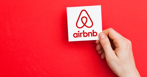 hand holding airbnb logo