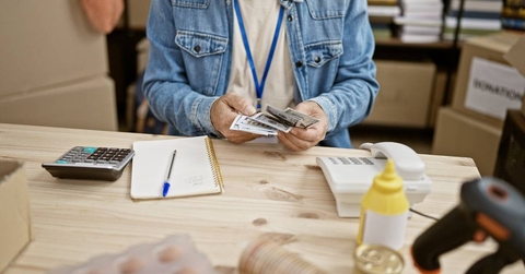 cluttered desk with bills, woman at desk crunching numbers