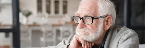 depressed senior man sitting on sofa