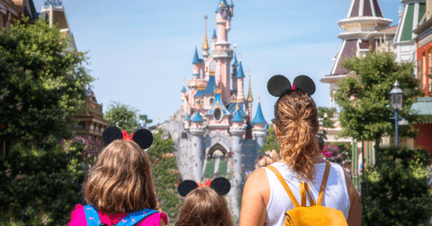 A family stands in front of the Princess Castle at Disney. 