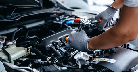 Mechanic repairing engine at garage workshop