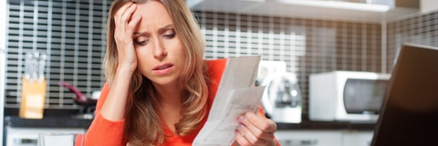 Stressed woman looking at bills