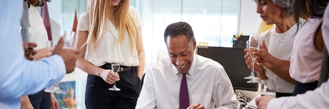 Coworkers celebrating colleague’s retirement in office