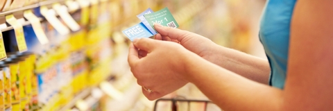 woman in supermarket with coupons