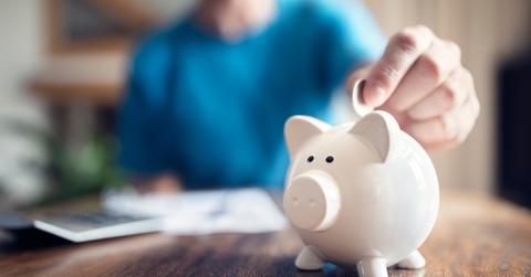 woman putting money in piggy bank