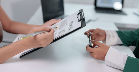 woman holding resume while interviewing for job