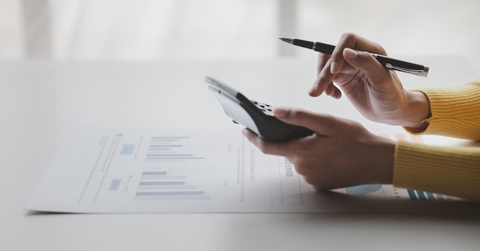 Businessman using calculator to calculate bills