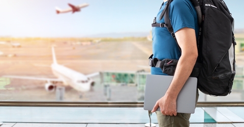 man traveling with laptop at airport