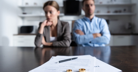 unhappy couple at table with divorce documents