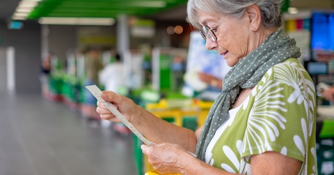 checks her grocery receipt