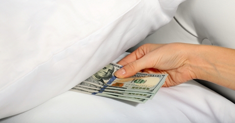 Woman hiding money under pillow