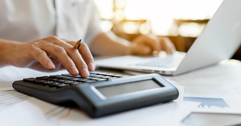businessman pressing on calculator