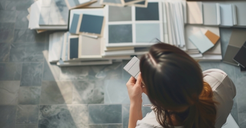 a person surrounded by various paint samples