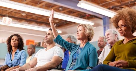 Woman Asking Question At Neighborhood Meeting In Community Center 