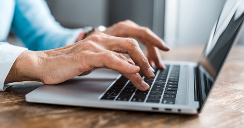 senior woman typing on laptop