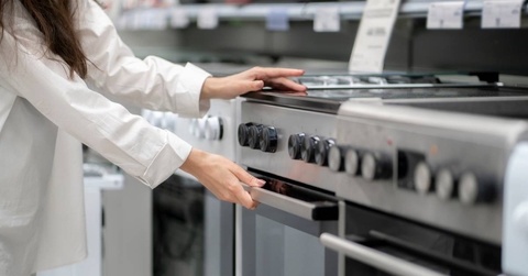woman buying a new kitchen stove in the electronics retail store