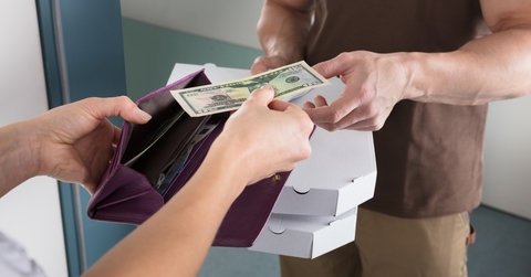 woman giving us dollar note for the pizza