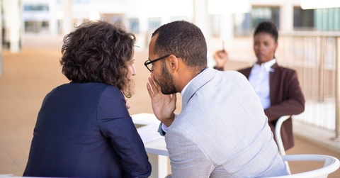 employees gossiping about young female colleague