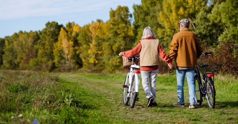 seniors pushing their bikes side by side