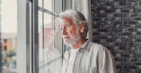 senior man looking in distance out of window