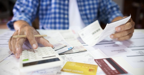 man sitting at desk calculate receipt of expenses