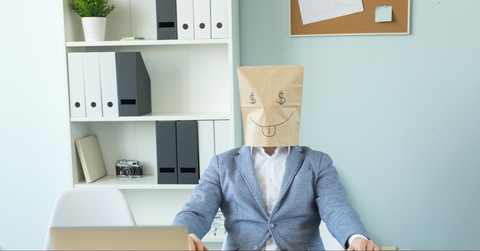 man at desk with bag on head
