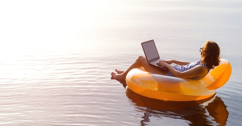 business woman working on a laptop in an inflatable ring in the water